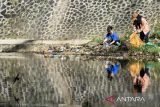 Relawan yang tergabung dalam River Clean Up mengangkut sampah di kawasan Cikapundung River Spot, Bandung, Jawa Barat, Minggu (14/7/2024). Ratusan kilogram sampah anorganik dari plastik hingga sampah tekstil diangkut dalam aksi tersebut sebagai wujud nyata kaum muda guna mencegah terjadinya kerusakan lingkungan dan pencemaran. ANTARA FOTO/Novrian Arbi/agr