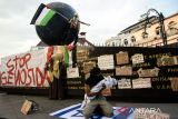 Seniman yang tergabung dalam Bandung Spirit of Palestine menampilkan teatrikal saat aksi solidaritas seni mendukung Palestina di Monumen Solidaritas Asia Afrika, Bandung, Jawa Barat, Minggu (14/7/2024).Aksi dukungan yang ke-101 tersebut dilakukan sebagai bentuk konsistensi dalam seruan dihentikannya kekerasan serta kejahatan kemanusiaan oleh Israel sekaligus mendukung kemerdekaan penuh untuk Palestina. ANTARA FOTO/Novrian Arbi/agr