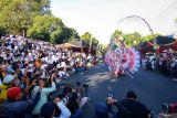 Penonton dan fotografer memotret model yang memperagakan kostum kreasinya pada gelaran Banyuwangi Ethno Carnival (BEC) di Gesibu Blambangan, Banyuwangi, Jawa Timur, Sabtu (13/7/2024). Banyuwangi Ethno Carnival 2024 yang masuk dalam Kharisma Even Nusantara tersebut mengangkat tema Ndaru Deso Revival of Village dengan menampilkan 130 model yang memperagakan kostum bernuansa potensi Desa di Banyuwangi. ANTARA Jatim/Budi Candra Setya/mas.