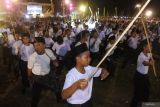 Sejumlah pelajar menampilkan Tari Ojung saat pemecahan Rekor MURI di Alun-alun Bondowoso, Jawa Timur, Sabtu (13/7/2024) malam. Pagelaran Tari Ojung tersebut berhasil memecahkan Rekor MURI dengan peserta pelajar terbanyak yaitu melibatkan 1.058 siswa dari sekolah tingkat SD, SMP dan SMA se-Kabupaten Bondowoso. Antara Jatim/Seno/mas.