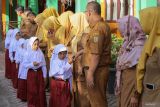 Sejumlah siswa bersalaman dengan guru sebelum memasuki kelas saat hari pertama masuk sekolah di SD Negeri 55, Banda Aceh, Aceh, Senin (15/7/2024). Hari pertama masuk sekolah tahun ajaran 2024/2025 untuk SD, SMP, SMA dan sederajat dimulai secara serentak setelah libur panjang akhir semester bertepatan dengan libur Lebaran Idul Adha 1445 H. ANTARA FOTO/Khalis Surry