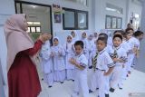 Seorang guru memberi pengarahan kepada siswa sebelum memasuki kelas saat hari pertama masuk sekolah di SD Al Azhar Banda Aceh, Aceh, Senin (15/7/2024). Hari pertama masuk sekolah tahun ajaran 2024-2025 untuk SD, SMP, SMA dan sederajat dimulai secara serentak di Indonesia, setelah libur panjang akhir semester bertepatan dengan libur Lebaran Idul Adha 1445 H. ANTARA FOTO/Khalis Surry