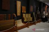 Pengunjung menyaksikan berbagai jenis kain tenun songket tradisional dari sejumlah provinsi di Indonesia saat berlangsung pameran Wastra  Nusantara di Museum Aceh, Banda Aceh, Senin (15/7/2024). Pameran Wastra Nusantara yang berlangsung hingga Desember 2024 di Museum Aceh itu menampilkan sebanyak 58 jenis kain tenun songket  dari beberapa daerah yang menggunakan bahan  benang sutera, benang emas, kapas atau katun itu bertujuan melestarikan nilai budaya, memajukan industri tekstil dan  industri fhashion nasional. ANTARA FOTO/Ampelsa.