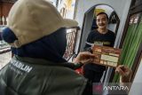 Panitia Pemutakhiran Data Pemilih (pantarlih) PPS Cikutra meminta izin kepada warga untuk menempelkan stiker tanda bukti pencocokan dan penelitian (coklit) daftar pemilih Pemilu Kepala Daerah (pilkada) Jawa Barat 2024 di Bandung, Jawa Barat, Senin (15/7/2024). Berdasarkan data KPU Jawa Barat, pemutakhiran dan pendaftaran pemilih untuk Pilkada Jawa Barat tahun 2024 sudah mencapai 94 persen dengan total 33.749.090 data yang sudah tercoklit. ANTARA FOTO/Novrian Arbi/agr