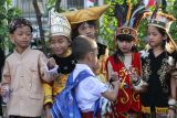 Sejumlah pelajar berpakaian adat menyapa teman sekolahnya saat hari pertama masuk sekolah di SD Negeri Kaliasin I, Surabaya, Jawa Timur, Senin (15/7/2024). Hari pertama masuk sekolah di tempat itu sejumlah pelajar dan tenaga pendidik mengenakan pakaian adat, wayang dan super hero. ANTARA Jatim/Didik Suhartono/mas.