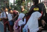 Sejumlah tenaga pendidik dengan mengenakan kostum super hero menyambut sejumlah pelajar saat hari pertama masuk sekolah di SD Negeri Kaliasin I, Surabaya, Jawa Timur, Senin (15/7/2024). Hari pertama masuk sekolah di tempat itu sejumlah pelajar dan tenaga pendidik mengenakan pakaian adat, wayang dan super hero. ANTARA Jatim/Didik Suhartono/mas.