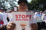 Pelajar memperlihatkan poster anti perundungan saat pembukaan pelaksanaan Masa Pengenalan Lingkungan Sekolah (MPLS) di SMK Negeri 5, Surabaya, Jawa Timur, Senin (15/7/2024). Pembukaan MPLS tersebut tercatat dalam Museum Rekor Dunia Indonesia (MURI) dengan tiga kategori sekaligus yaitu, Deklarasi Anti Perundungan secara serentak oleh siswa baru SMA, SMK dan SLB terbanyak, Pembuatan Poster Anti Perundungan oleh siswa baru SMA, SMK dan SLB terbanyak serta Pembagian Seragam Sekolah secara serentak kepada siswa baru SMA, SMK dan SLB dari keluarga tidak mampu terbanyak. ANTARA Jatim/Moch Asim/um.