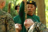 Pelatih memberikan air yang tersimpan di dalam batang kayu liana kepada Marinir Amerika (USMC) pada materi bertahan hidup di hutan  (jungle survival) Latihan bersama Platoon Exchange (Platex) 2024 di Pusat Latihan Pertempuran (PLP) Marinir 5 Baluran, Karang Tekok, Situbondo, Jawa Timur, Selasa (16/7/2024). Latihan bertahan hidup di hutan dengan mengolah sumberdaya alam yang bisa dimanfaatkan itu sebagai bekal pengetahuan ketika prajurit berada dalam kondisi darurat di dalam hutan. Pelatih memberikan materi menangkap biawak kepada Marinir Amerika (USMC) pada Latihan bersama Platoon Exchange (Platex) 2024 di Pusat Latihan Pertempuran (PLP) Marinir 5 Baluran, Karang Tekok, Situbondo, Jawa Timur, Selasa (16/7/2024). Latihan bertahan hidup di hutan dengan mengolah sumberdaya alam yang bisa dimanfaatkan itu sebagai bekal pengetahuan ketika prajurit berada dalam kondisi darurat di dalam hutan. ANTARA FOTO/Budi Candra SetyaANTARA FOTO/Budi Candra Setya (ANTARA FOTO/Budi Candra Setya)