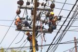 Pekerja mengganti kabel pada jaringan listrik tegangan menengah di Kota Kediri, Jawa Timur, Rabu (17/7/2024). PT PLN (Persero) mencanangkan Program Percepatan Pengambangan Energi Terbarukan guna mencapai kapasitas pembangkit energi baru terbarukan (EBT) hingga 75 persen atau sekitar 61,5 GW pada 2040. Antara Jatim/Prasetia Fauzani/um