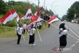 Sejumlah warga membawa bendera untuk dikibarkan di sisi kiri dan kanan jalan nasional pada kegiatan Pencanangan Gerakan Nasional Pembagian 10 juta Bendera Merah Putih di kawasan gunung Geurutee, kabupaten Aceh Besar, Aceh, Rabu (17/7/2024). Gerakan Nasional pembagian bendera yang digagas Kementerian Dalam Negeri untuk memeriahkan HUT ke-79 Kemerdekaan RI di daerah melibatkan seluruh  kepala desa dan  tokoh pemuda, TNI dan Polri serta ormas itu guna membangkitkan semangat kebersamaan, nasionalisme dan cinta tanah air. ANTARA FOTO/Ampelsa.