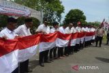 Penjabat Bupati Aceh Besar, Muhammad Iswanto  (kanan) memberikan arahan kepada sejumlah kepala desa dan tokoh pemuda saat Pencanangan Gerakan Nasional Pembagian 10 juta Bendera Merah Putih di kawasan gunung Geurutee, kabupaten Aceh Besar, Aceh, Rabu (17/7/2024). Gerakan Nasional pembagian bendera yang digagas Kementerian Dalam Negeri untuk memeriahkan HUT ke-79 Kemerdekaan RI di daerah melibatkan seluruh  kepala desa dan  tokoh pemuda, TNI dan Polri serta ormas itu guna membangkitkan semangat kebersamaan, nasionalisme dan cinta tanah air. ANTARA FOTO/Ampelsa.