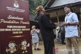 Ketua Divisi Sosdiklih Parmas KPU Jawa Barat Hedi Ardia (kanan) berbincang dengan warga adat saat sosialisasi Pilkada Jawa Barat 2024 di Kampung Naga, Kabupaten Tasikmalaya, Jawa Barat, Rabu (17/7/2024). Sosialisasi yang digelar oleh KPU Jawa Barat dengan mendatangi dan mengumpulkan warga adat itu guna mengingatkan warga Kampung Naga untuk memberikan hak suaranya dalam pilkada pada 27 November 2024. ANTARA FOTO/Adeng Bustomi/agr