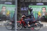 Pengendara melintas di dekat mural bertema kinerja pemerintahan Presiden Jokowi di Kabupaten Ciamis, Jawa Barat, Kamis (18/7/2024). Mural tersebut banyak ditemukan di sejumlah titik di pusat kota sebagai wujud ekspresi ucapan dari warga atas apresiasi kinerja pemerintah di era Presiden Joko Widodo. ANTARA FOTO/Adeng Bustomi/agr
