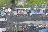 Foto udara suasana median Jalan Orang Kayo Pingai yang dipadati pedagang kaki lima di luar kawasan Pasar Rakyat Talang Banjar, Jambi, Rabu (17/7/2024). Pasar Rakyat Talang Banjar yang selesai dibangun pada 2017 dengan daya tampung sekitar 1.000 pedagang tersebut hingga kini belum berfungsi optimal dengan keterisian lapak kurang dari 30 persen karena sejumlah pedagang lebih memilih mendirikan bangunan liar di tepi jalan raya. ANTARA FOTO/Wahdi Septiawan/rwa.