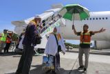 Petugas membantu memayungi jamaah haji yang tergabung dalam kelompok terbang (kloter) 09-BTJ setibanya di Bandara Internasional Sultan Iskandar Muda (SIM), Aceh Besar, Aceh, Jumat (19/7/2024). PPIH Debarkasi Aceh menyebutkan hingga saat ini sebanyak 3.525 jamaah haji Aceh yang tergabung dalam sembilan kloter telah kembali ke Tanah Air usai menunaikan ibadah haji. ANTARA/Khalis Surry