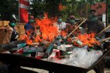 Sejumlah pejabat Kejaksaan dan BNN Kota Pontianak menyulut api saat membakar ratusan kotak berisi bungkusan rokok saat pemusnahan barang bukti tindak pidana di Kejaksaan Negeri Pontianak di Pontianak, Kalimantan Barat, Kamis (18/7/2024). Kejari Pontianak melakukan pemusnahan barang bukti dari 79 perkara yang telah berkekuatan hukum tetap (inkracht) berupa senjata api, narkotika, ponsel, rokok, makanan dan minuman siap saji ilegal dan minuman keras. ANTARA FOTO/Jessica Wuysang/nym.