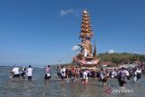 Sejumlah umat Hindu mengarak bade atau menara bertingkat tujuh saat melintasi pantai pada upacara ngaben massal di Desa Adat Karangsari, Nusa Penida, Kabupaten Klungkung, Bali, Kamis (18/7/2024). Upacara ngaben massal tersebut digelar setiap lima tahun sekali dengan berjalan melintasi pantai. ANTARA FOTO/Nyoman Hendra Wibowo/wsj.