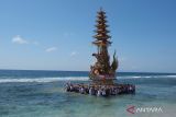 Sejumlah umat Hindu mengarak bade atau menara bertingkat tujuh saat melintasi pantai pada upacara ngaben massal di Desa Adat Karangsari, Nusa Penida, Kabupaten Klungkung, Bali, Kamis (18/7/2024). Upacara ngaben massal tersebut digelar setiap lima tahun sekali dengan berjalan melintasi pantai. ANTARA FOTO/Nyoman Hendra Wibowo/wsj.