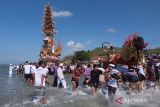 Sejumlah umat Hindu mengarak bade atau menara bertingkat tujuh dan tempat pembakaran jenazah saat melintasi pantai pada upacara ngaben massal di Desa Adat Karangsari, Nusa Penida, Kabupaten Klungkung, Bali, Kamis (18/7/2024). Upacara ngaben massal tersebut digelar setiap lima tahun sekali dengan berjalan melintasi pantai. ANTARA FOTO/Nyoman Hendra Wibowo/wsj.