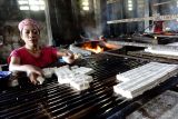 Pekerja mengambil tahu untuk selanjutnya digoreng di industri rumahan produksi tahu Dusun Bapang, Desa Sumbermulyo, Kecamatan Jogoroto, Kabupaten Jombang, Jawa Timur, Sabtu (20/7/2024). Menurut pengusaha, produksi tahu yang sudah digeluti sejak tahun 2012 lalu itu bisa memproduksi 1,5 ton tahu mentah serta 500 kuintal tahu goreng dalam sehari dengan pangsa pasar ke wilayah Gresik dan Surabaya. Antara Jatim/Syaiful Arif/um