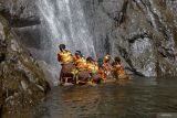 Sejumlah remaja mengambil air menggunakan kendi saat prosesi ritual Siraman Air Terjun Sedudo di Nganjuk, Jawa Timur, Sabtu (20/7/2024). Ritual yang dilaksanakan setahun sekali saat bulan Suro (penanggalan Jawa) sejak zaman kerajaan Majapahit itu sebagai tolak bala dan simbol pembersihan diri. ANTARA Jatim/Muhammad Mada/mas.