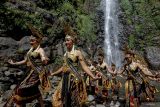 Sejumlah remaja menari saat prosesi ritual Siraman Air Terjun Sedudo di Nganjuk, Jawa Timur, Sabtu (20/7/2024). Ritual yang dilaksanakan setahun sekali saat bulan Suro (penanggalan Jawa) sejak zaman kerajaan Majapahit itu sebagai tolak bala dan simbol pembersihan diri. ANTARA Jatim/Muhammad Mada/mas.