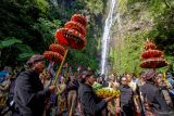 Sejumlah warga mengikuti prosesi ritual Siraman Air Terjun Sedudo di Nganjuk, Jawa Timur, Sabtu (20/7/2024). Ritual yang dilaksanakan setahun sekali saat bulan Suro (penanggalan Jawa) sejak zaman kerajaan Majapahit itu sebagai tolak bala dan simbol pembersihan diri. ANTARA Jatim/Muhammad Mada/mas.