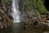 Sejumlah remaja mengambil air menggunakan kendi saat prosesi ritual Siraman Air Terjun Sedudo di Nganjuk, Jawa Timur, Sabtu (20/7/2024). Ritual yang dilaksanakan setahun sekali saat bulan Suro (penanggalan Jawa) sejak zaman kerajaan Majapahit itu sebagai tolak bala dan simbol pembersihan diri. ANTARA Jatim/Muhammad Mada/mas.