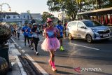 Pelari melintasi Jalan Asia Afrika saat mengikuti Pocari Sweat Run 2024 di Bandung, Jawa Barat, Minggu (21/7/2024). Pocari Sweat Run 2024 diikuti 15.800 pelari di Kota Bandung sementara 26.000 peserta lainnya mengikuti secara daring dari berbagai kota di Indonesia dengan berbagai kategori seperti 5K, 10 K, Half Marathon dan Marathon. ANTARA FOTO/Raisan Al Farisi/agr