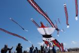 Sejumlah peserta berusaha menangkap layang-layang tradisional Bali yang diturunkan saat mengikuti perlombaan pada Festival Layangan Piala Gubernur Bali 2024 di Pantai Padanggalak, Denpasar, Bali, Minggu (21/7/2024). Kegiatan yang diselenggarakan oleh Komunitas Seni Layanan Bali bekerja sama dengan Pemerintah Provinsi Bali tersebut diikuti 1.340 peserta  untuk pelestarian permainan tradisional Bali. ANTARA FOTO/Nyoman Hendra Wibowo/wsj.