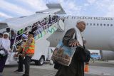 Jamaah haji kelompok terbang (kloter) BTJ-12 atau terakhir Debarkasi Aceh turun dari pesawat saat tiba di Bandara Internasional Iskandar Muda (SIM) Aceh Besar, Aceh, Senin (22/7/2024). Sebanyak 4.693 jamaah haji berserta petugas yang tergabung dalam 12 kloter Debarkasi Aceh telah kembali ke Tanah Air usai menunaikan ibadah haji 1445 H, serta jamaah Aceh berkurang 17 orang dari total 4.710 orang diberangkatkan di antaranya 15 orang meninggal dunia dan dua orang masih menjalani perawatan medis di Arab Saudi. ANTARA FOTO/Khalis Surry