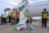 Jamaah haji kelompok terbang (kloter) BTJ-12 atau terakhir Debarkasi Aceh melakukan sujud Syukur saat tiba di Bandara Internasional Iskandar Muda (SIM) Aceh Besar, Aceh, Senin (22/7/2024). Sebanyak 4.693 jamaah haji berserta petugas yang tergabung dalam 12 kloter Debarkasi Aceh telah kembali ke Tanah Air usai menunaikan ibadah haji 1445 H, serta jamaah Aceh berkurang 17 orang dari total 4.710 orang diberangkatkan di antaranya 15 orang meninggal dunia dan dua orang masih menjalani perawatan medis di Arab Saudi. ANTARA FOTO/Khalis Surry