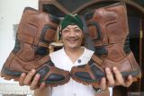 Seorang pembeli memperlihatkan sepatu kulit pilihannya di industri rumahan sepatu Legacy di Desa Gedangsewu, Kediri, Jawa Timur, Senin (22/7/2024). Industri rumahan sepatu berbahan baku kulit sapi tersebut mengandalkan permasaran secara daring sehingga mampu memiliki pelanggan dari berbagai daerah hingga negara Malaysia dan Singapura dengan harga jual Rp150 ribu sampai Rp750 ribu per pasang tergantung model dan ukuran. ANTARA Jatim/Prasetia Fauzani/mas.