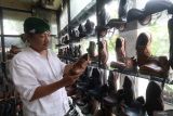 Seorang pembeli memilih sepatu kulit di industri rumahan sepatu Legacy di Desa Gedangsewu, Kediri, Jawa Timur, Senin (22/7/2024). Industri rumahan sepatu berbahan baku kulit sapi tersebut mengandalkan permasaran secara daring sehingga mampu memiliki pelanggan dari berbagai daerah hingga negara Malaysia dan Singapura dengan harga jual Rp150 ribu sampai Rp750 ribu per pasang tergantung model dan ukuran. ANTARA Jatim/Prasetia Fauzani/mas.