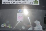 Kedatangan kloter terakhir jamaah haji Aceh. Seorang jamaah haji kelompok terbang (kloter) BTJ-12 atau terakhir Debarkasi Aceh menaiki bus Damri saat tiba di Bandara Internasional Iskandar Muda (SIM) Aceh Besar, Aceh, Senin (22/7/2024). Sebanyak 4.693 jamaah haji berserta petugas yang tergabung dalam 12 kloter Debarkasi Aceh telah kembali ke Tanah Air usai menunaikan ibadah haji 1445 H, serta jamaah Aceh berkurang 17 orang dari total 4.710 orang diberangkatkan di antaranya 15 orang meninggal dunia dan dua orang masih menjalani perawatan medis di Arab Saudi. ANTARA FOTO/Khalis SurryANTARA FOTO/Khalis Surry (ANTARA FOTO/Khalis Surry)