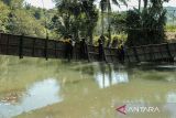 Siswa berusaha melintasi jembatan rusak di Neglasari, Lengkong, Kabupaten Sukabumi, Jawa Barat, Selasa (23/7/2024). Intensitas hujan yang tinggi dan meningkatnya debit air sungai Cikaso mengakibatkan jembatan penghubung antarkecamatan Lengkong dan Jampang Tengah terputus sejak sebulan terakhir sehingga menyebabkan akses warga terganggu. ANTARA FOTO/Henry Purba/agr
