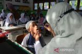 Petugas Kesehatan Masyarakat (Puskesmas) memeriksa kesehatan mulut dan gigi murid baru kelas 1 SDN  No.20 Banda Aceh, Aceh, Selasa (23/7/2024). Pemeriksaan kesehatan murid baru dan termasuk juga murid kelas VI yang bertepatan pada Hari Anak Nasional (HAN)  di sekolah tersebut,  merupakan agenda rutin setaiap tahun ajaran baru yang bertujuan  melindungi anak dari berbagai penyakit , sekolah sehat dan anak cerdas. ANTARA FOTO/Ampelsa.