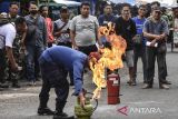 Anggota Damkar memadamkan api dari tabung gas saat Simulasi Penanganan Kebakaran di Pasar Manis Ciamis, Kabupaten Ciamis, Jawa Barat, Rabu (24/7/2024). Simulasi yang melibatkan Himpunan Pedagang Pasar (HPP) Ciamis itu dalam ranggka memberikan pemahaman dan tata cara penanganan pertama memadamkan api saat terjadi bencana kebakaran di Lingkungan Pasar. ANTARA FOTO/Adeng Bustomi/agr