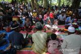 Sejumlah petani menggelar  zikir dan doa bersama saat berlangsung  tradisi Kenduri Blang (sawah)  di desa Lam Aling, kabupaten Aceh Besar, Aceh, Kamis (25/7/2024).  Tradisi Kenduri Blang atau kenduri sawah saat padi mulai berperut atau bunting  dihadiri sejumlah kelompok tani dengan ritual menggelar zikir dan doa bersama itu bertujuan untuk mendapatkan berkah agar hasil panen melimpah. ANTARA FOTO/Ampelsa.