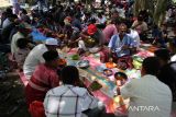 Sejumlah petani  makan bersama seusai berzikir dan  berdoa saat berlangsung  tradisi Kenduri Blang (sawah)  di desa Lam Aling, kabupaten Aceh Besar, Aceh, Kamis (25/7/2024).  Tradisi Kenduri Blang atau kenduri sawah saat padi mulai berperut atau bunting  dihadiri sejumlah kelompok tani dengan ritual menggelar zikir dan doa bersama itu bertujuan untuk mendapatkan berkah agar hasil panen melimpah. ANTARA FOTO/Ampelsa.