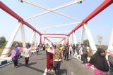 Warga berjalan kaki melewati jembatan Jongbiru yang dibangun di atas sungai Brantas saat peresmian jembatan Jongbiru di Kediri, Jawa Timur, Jumat (26/7/2024). Jembatan Jongbiru yang dibangun dengan anggaran sebesar Rp27 miliar dari Anggaran Pendapatan Belanja Negara (APBN) tahun 2023-2024 tersebut telah diresmikan sebagai upaya mendukung lalu lintas kendaraan menuju bandara Dhoho sekaligus penghubung antara kota dengan kabupaten Kediri. ANTARA Jatim/Prasetia Fauzani/mas.