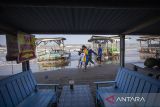 Pengunjung melintas di tepi pantai objek wisata Pantai Karangsong, Indramayu, Jawa Barat, Sabtu (27/7/2024). Akibat terjangan gelombang pasang yang terjadi sejak sebulan terakhir menyebabkan abrasi dan banyak lapak pedagang yang mengalami kerusakn di objek wisata tersebut. ANTARA FOTO/Dedhez Anggara/agr