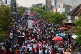 Peserta parade membagikan dan mengibarkan Bendera Merah Putih saat Parade Senja dan pembagian Bendera Merah Putih di Kota Madiun, Jawa Timur, Sabtu (27/7/2024). Pemkot Madiun membagikan 10.000 Bendera Merah Putih sebagai gerakan nasional untuk memeriahkan HUT ke-79 Kemerdekaan RI guna membangkitkan semangat nasionalisme serta kecintaan pada Negara Kesatuan Republik Indonesia (NKRI). Antara Jatim/Siswowidodo/um