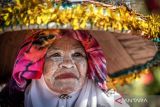 Seorang pedagang memakai topi hias saat Festival Pasar Terapung Lok Baintan 2024 di Sungai Martapura, Kecamatan Sungai Tabuk, Kabupaten Banjar, Kalimantan Selatan, Minggu (28/7/2024). Festival bertajuk Pesona Susur Sungai Urang Banjar yang diikuti sekitar 500 pedagang pasar terapung itu bertujuan melestarikan budaya dan kultur masyarakat pesisir Sungai Martapura. ANTARA FOTO/Bayu Pratama S/wsj.