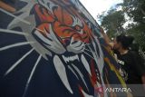 Pegiat seni menyelesaikan pembuatan mural harimau sumatera (Panthera tigris Sumatrae) saat peringatan Hari Konservasi Alam Nasional (HKAN) di kawasan hutan Madapi Taman Nasional Kerinci Seblat (TNKS) di Kabupaten Rejang Lebong, Bengkulu, Jumat (26/7/2024). Balai Besar TNKS bekerjasama Pemerintah Provinsi Bengkulu, Lembaga Swadaya Masyarakat Lingkar Inisiatif dan pegiat seni memperingati HKAN 2024 yang menekankan pentingnya menjaga habitat satwa dikarenakan memiliki peran penting dalam mempertahankan keseimbangan hutan. ANTARA FOTO/Muhammad Izfaldi