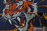 Pegiat seni menyelesaikan pembuatan mural harimau sumatera (Panthera tigris Sumatrae) saat peringatan Hari Konservasi Alam Nasional (HKAN) di kawasan hutan Madapi Taman Nasional Kerinci Seblat (TNKS) di Kabupaten Rejang Lebong, Bengkulu, Jumat (26/7/2024). Balai Besar TNKS bekerjasama Pemerintah Provinsi Bengkulu, Lembaga Swadaya Masyarakat Lingkar Inisiatif dan pegiat seni memperingati HKAN 2024 yang menekankan pentingnya menjaga habitat satwa dikarenakan memiliki peran penting dalam mempertahankan keseimbangan hutan. ANTARA FOTO/Muhammad Izfaldi