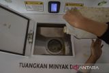 Warga memasukan minyak jelantah pada mesin setor minyak jelantah menjadi rupiah Ucollect di Saung Bambu Cibadak, Bandung, Jawa Barat, Selasa (30/7/2024). Mesin tersebut menampung minimal satu liter minyak bekas masak atau minyak jelantah warga yang ditukarkan dengan nominal Rp6.000 rupiah melalui dompet elektronik sebagai inovasi teknologi dalam mengolah minyak jelantah menjadi biodiesel sekaligus menjaga lingkungan dari limbah minyak. ANTARA FOTO/Novrian Arbi/agr