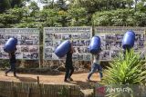 Anggota Kelompok Tani Sinar Jaya mengangkut tong plastik saat peresmian sinergi program Pengembangan Ayam Rancage Kota Tasikmalaya (Paranje Tasik) di Urug, Kota Tasikmalaya, Jawa Barat, Selasa (30/7/2024). Kantor Perwakilan Bank Indonesia Tasikmalaya dengan Pemeritah Kota Tasikmalaya memberikan bantuan kepada tujuh kelompok tani dalam pemberdayaan ekonomi masyarakat berbasis ekonomi sirkular dengan metode mini closed house untuk budi daya magot dan azolla sebagai campuran pakan alternatif. ANTARA FOTO/Adeng Bustomi/agr