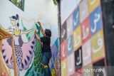 Mahasiswa membuat mural di Gang Cikapundung, Braga, Bandung, Jawa Barat, Selasa (30/7/2024). Mahasiswa dan dosen jurusan DKV Universitas Pasundan menghias Gang Cikapundung di Kawasan Wisata Braga dengan mural yang bertemakan kebudayaan dan sejarah guna memberikan daya tarik baru yang diharapkan mampu meningkatkan kunjungan wisata ke kawasan tersebut. ANTARA FOTO/Raisan Al Farisi/agr