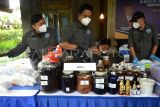 Petugas Badan Narkotika Nasional (BNN) menata barang bukti kasus laboratorium rahasia (clandestine lab) narkotika saat konferensi pers di sebuah vila di kawasan Desa Kelusa, Gianyar, Bali, Selasa (23/7/2024). BNN bekerja sama dengan sejumlah instansi terkait mengungkap kasus laboratorium rahasia di tenda yang dibangun di area vila untuk pembuatan narkotika jenis N,N-Dimethyltryptamine (DMT) pertama di Indonesia yang diproduksi tersangka warga negara Filipina berinisial DAS dan diinisiasi oleh warga Yordania berinisial AMI yang hingga kini masih dalam pengejaran. ANTARA FOTO/Fikri Yusuf/nym. 